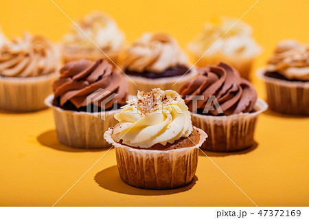 Vanilla muffin in a close-up on yellow background. 47372169