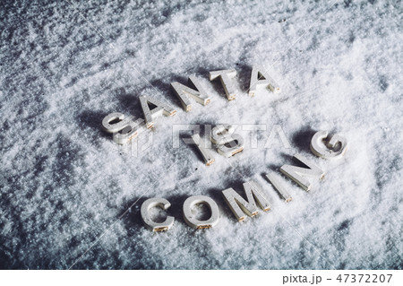 SANTA IS COMING writing on white snowy background. 47372207