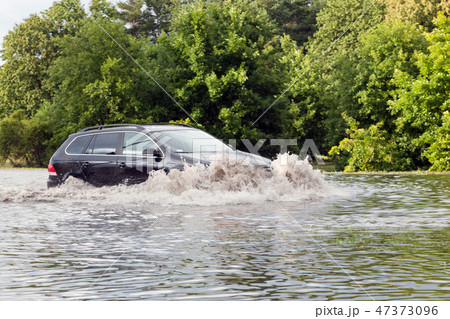 Car trying to drive against flood on the street in Gdansk, Poland. 47373096