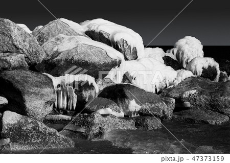 Snowy and icy rocks in the ocean. Black and white Snowy and icy rocks in the ocean. Black and white 47373159