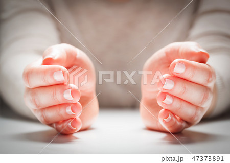 Woman's hands in gesture of protection, care. Concept insurance, security 47373891