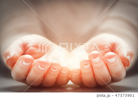Light in woman's hands. Concepts of sharing, giving, new life Light in woman's hands. Concepts of sharing, giving, new life 47373901