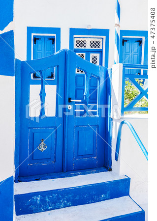 Traditional Greek stone house, blue gate and window shutters, Santorini island, Greece. 47375408