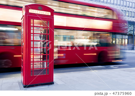 London, UK. Red telephone booth and red bus passing. Symbols of England. 47375960