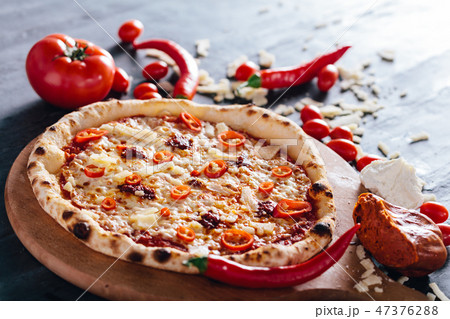 Pizza with hot pepper, cheese and meat spread 47376288