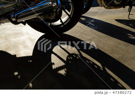 バイクツーリング 駐輪場 低い日差しに伸びるシルエット a バイクツーリング 駐輪場 低い日差しに伸びるシルエット a 47380272