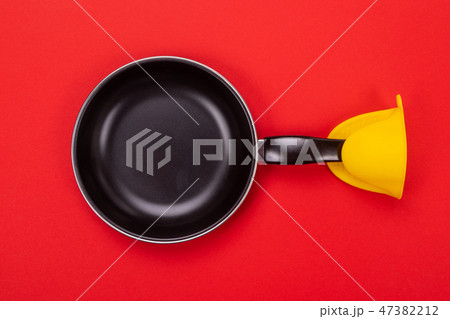 Frying pan with oven MITT isolated on red background 47382212