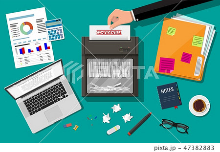 Hand putting paper in shredder machine. 47382883