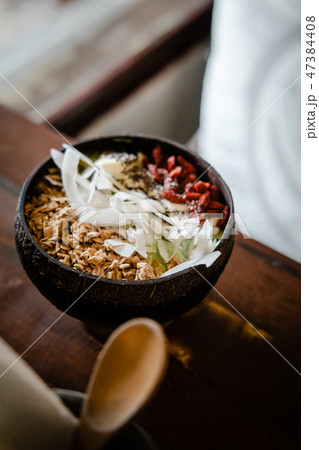 Green smoothie bowl with coconut on wooden table Green smoothie bowl with coconut on wooden table 47384408