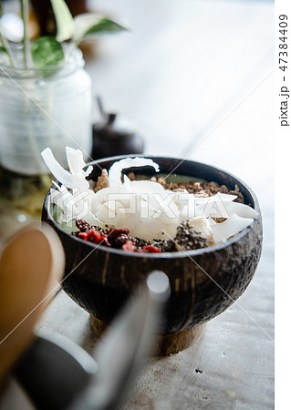 Green smoothie bowl with coconut on wooden table Green smoothie bowl with coconut on wooden table 47384409