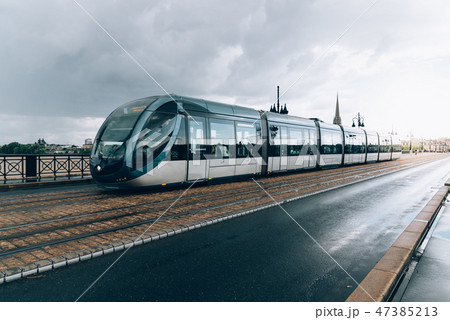 Modern city tram crossing bridge after rain Modern city tram crossing bridge after rain 47385213