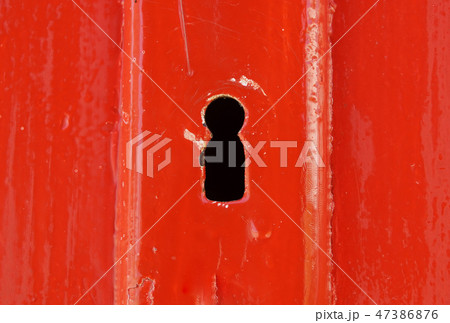 Detail of old wooden red painted door with heart shaped key hole 47386876