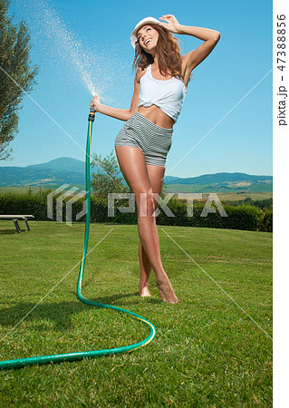 Beautiful young woman having fun in summer garden with garden ho Beautiful young woman having fun in summer garden with garden ho 47388856