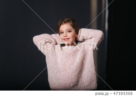 Beautiful young model in a peach color knitted sweater. Fashion makeup and hairstyle 47393308