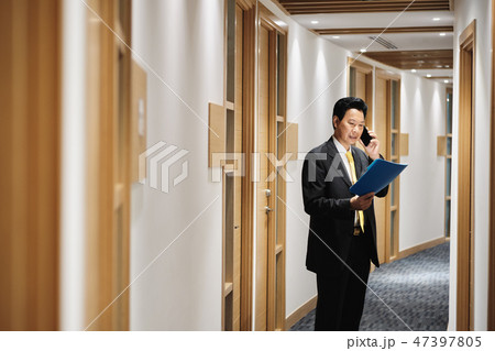 Asian Manager Working As Banking Agent Talking On Cell Phone 47397805