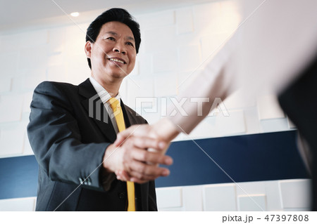 Handshake Between Happy Asian Manager And Hispanic Businesswoman In Office 47397808