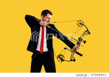 Businessman aiming at target with bow and arrow, isolated on yellow background 47399955