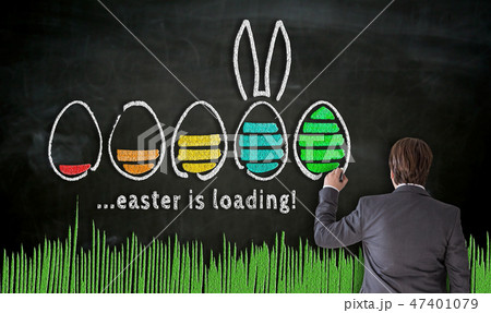 Businessman paints with chalk Easter concept on blackboard 47401079