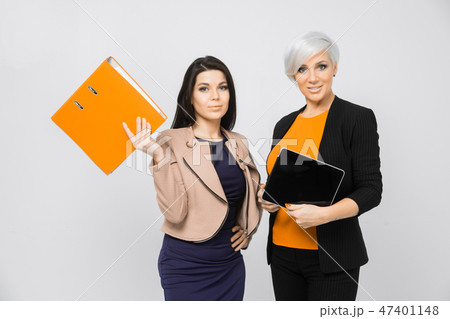Portrait of two ladies with document folder and tablet in hand isolated on white background Portrait of two ladies with document folder and tablet in hand isolated on white background 47401148
