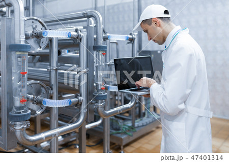 Technologist with a laptop in his hands at the dairy plant 47401314