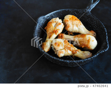 Fried chicken legs on an old pan on a black table. 47402641