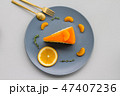 A sliced piece of orange cake on grey dish  47407236