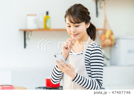 スマホでレシピ検索をする主婦　キッチン　台所 47407746