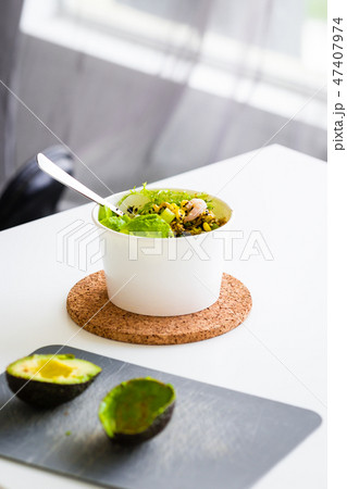 Green salad to go in white paper bowl 47407974