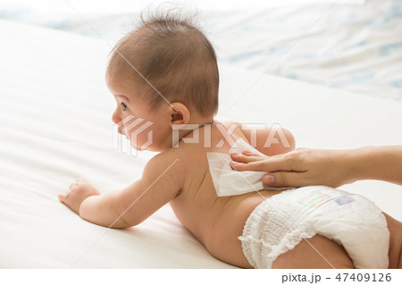 Mother cleaning up body and leg baby by wet tissue 47409126