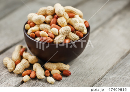 Roasted peanuts in the shell and peeled in a cup Roasted peanuts in the shell and peeled in a cup 47409616