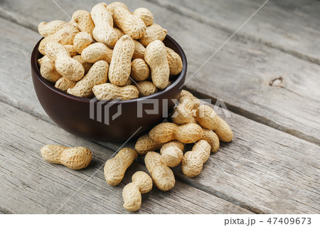 Peanuts in the shell, in a wooden cup on the table 47409673