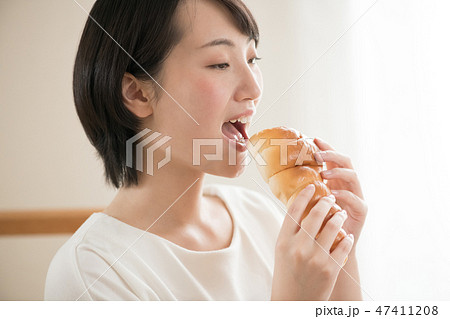 チョココロネを食べる若い日本人女性 47411208