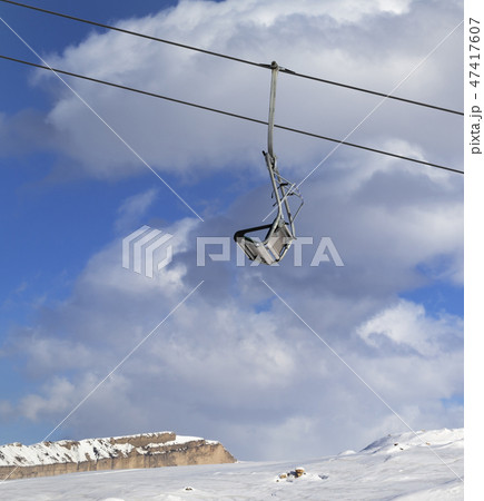 Snowy slope, ski-lift and blue sky with clouds 47417607