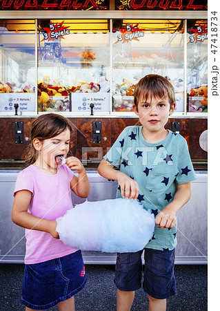Children eating candy floss at the amusement park 47418734