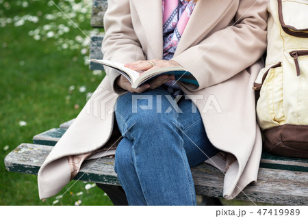 girl at the park reading a book 47419989