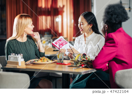 Three young single women reading book about finding husband 47422104