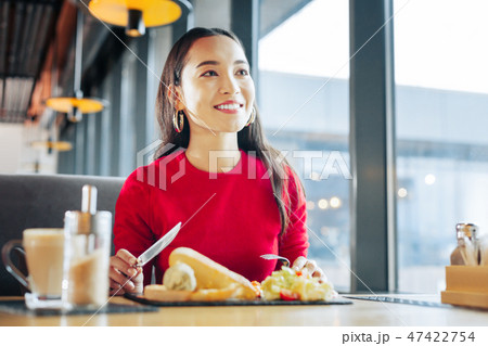 Close up of beaming appealing woman eating breakfast in cafe Close up of beaming appealing woman eating breakfast in cafe 47422754