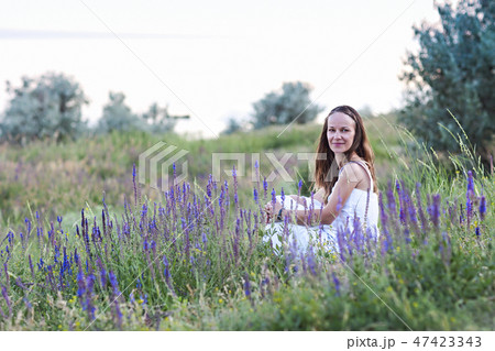 Brunette woman sitting in the grass 47423343