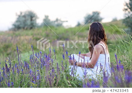 Woman sitting back in the grass. 47423345