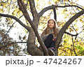 Beautiful girl sitting on a tree 47424267