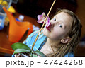 Girl sniffing beautiful orchid 47424268