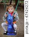 A girl riding a swing in the park 47424272