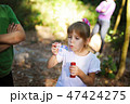 Girl playing in a park and blows bubbles 47424275