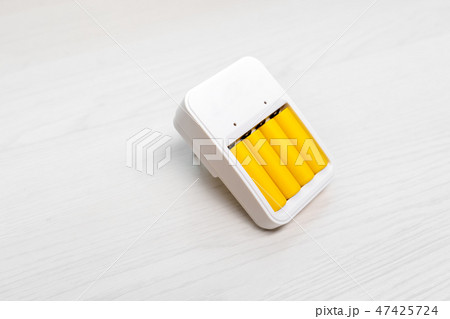 Image of charger with two yellow batteries 47425724