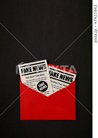 Envelope with FAKE NEWS newspapers over black 47425942
