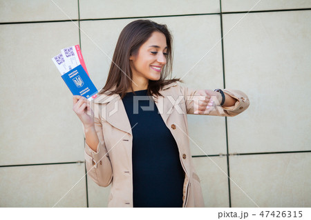 Image of European Woman Having Beautiful Brown Hair Smiling While Holding Passport and Air Tickets Image of European Woman Having Beautiful Brown Hair Smiling While Holding Passport and Air Tickets 47426315