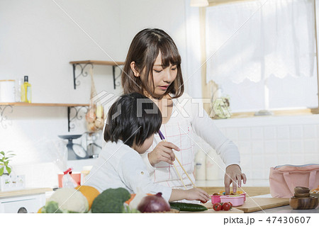子育てをしながらお弁当を作るお母さん 子育てをしながらお弁当を作るお母さん 47430607