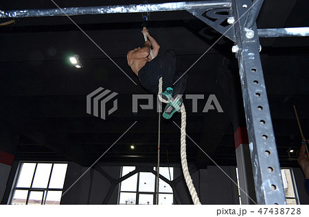 Crossfit athlete climbing the rope in gym Crossfit athlete climbing the rope in gym 47438728