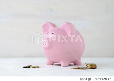 Pink piggy bank with loose cash coins Pink piggy bank with loose cash coins 47442037