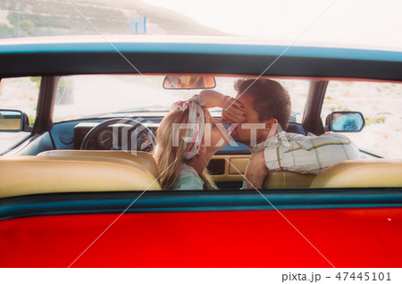 Young girl in white dress and man kissing in car 47445101
